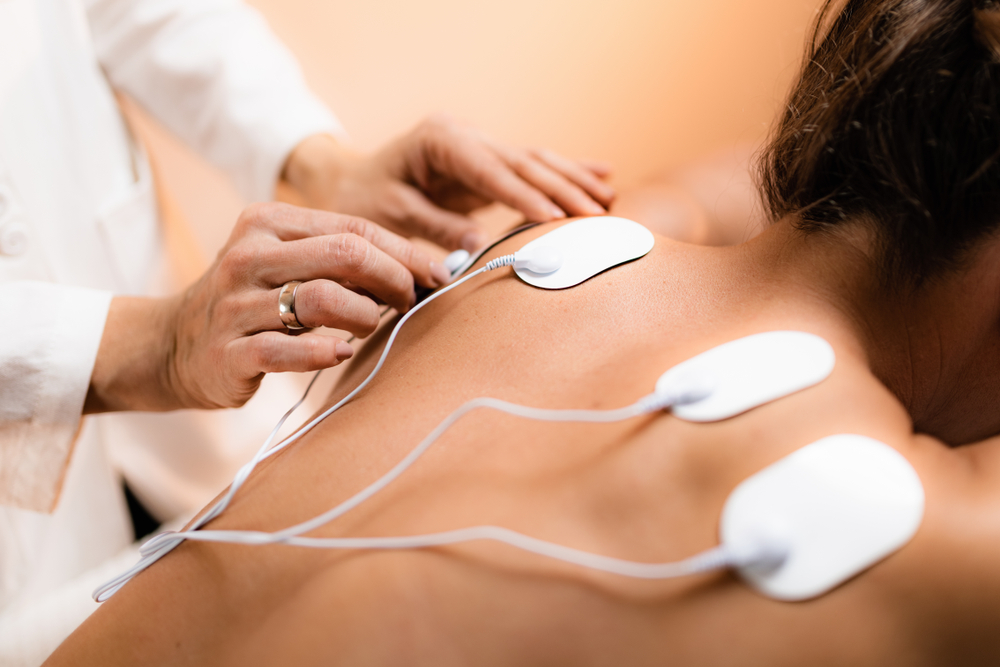 doctor placing TENS pads on patients back